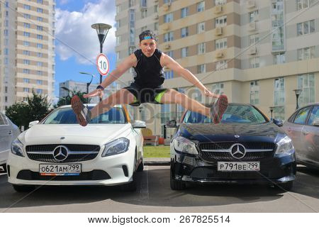MOSCOW - JUN 20, 2018: Jumping man (with MR) and two Mercedes Benz cars of Moscow carsharing company You drive in park, carsharing is system of short-term car rental
