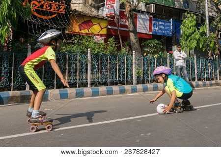 Kolkata, West Bengal, India - March 15th 2015 : Children Rollerskating With White Ball On Park Stree
