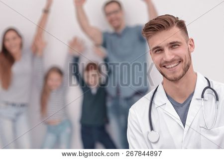 portrait of a family doctor on the background of his happy patie