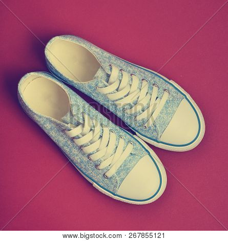 Classic Retro Sneakers On A Red Background. Top View. Women's Shoes.