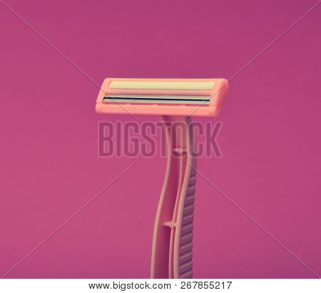 Pink Disposable Razor For Depilation On A Pink Background.