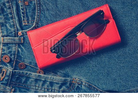 Women's Things And Accessories. Classic Sunglasses, Red Leather Purse, Jeans.