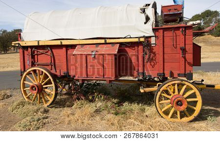 Vintage Red Wooden Covered Wagon In Field