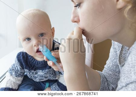 Mom Cleans Baby's Nose Using A Nasal Aspirator
