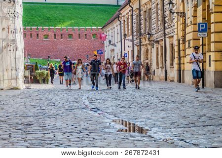 Krakow, Poland - September 3, 2016: Peopke Walk On A Cobbled Street In The Center Of Krakow, Poland