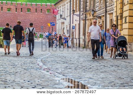 Krakow, Poland - September 3, 2016: Peopke Walk On A Cobbled Street In The Center Of Krakow, Poland