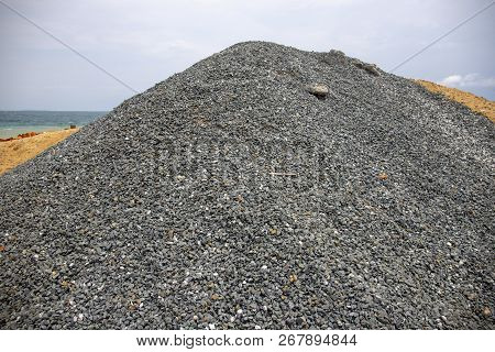 Huge Pile Of Grey Gravel On Coast. Construction Site Material. Big Gravel Heap Outdoor. Construction
