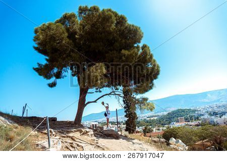 Girl In The Ruins Of An Ancient Acropolis Under A Large Tree