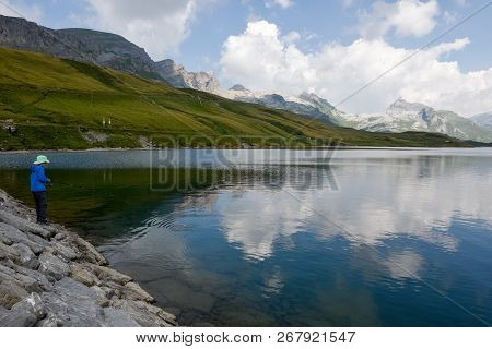 Boy Fishing At Lake Tannensee On The Swiss Alps