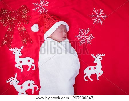 Newborn Baby Sleeping On Santa Het And Red Background,