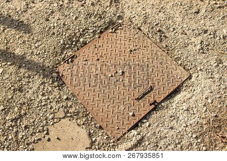 Sewage Iron Cover Close Up Shot Near Residentual House In Crumbly Concrete.
