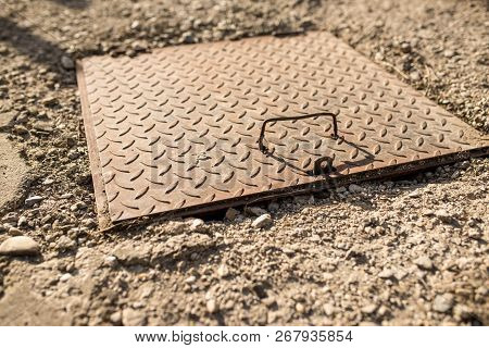 Sewage Iron Cover Close Up Shot Near Residentual House In Crumbly Concrete.