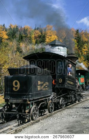 MOUNT WASHINGTON COG RAILWAY, BRETTON WOODS, NH - October 6, 2007:  Mount Washington cog railway locomotive in foliage season with blue sky.