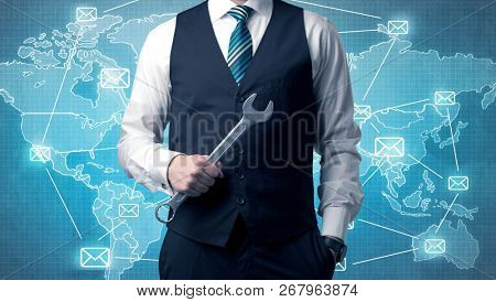 Businessman holding tool with global map graphic on the background