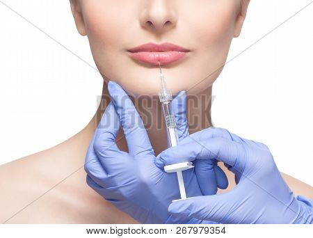 The Doctor Cosmetologist Makes Injection On The Lips Of A Beautiful Woman In A Beauty Salon.cosmetol