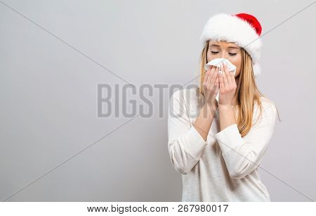 Sick Young Woman With Tissues On A Gray Background