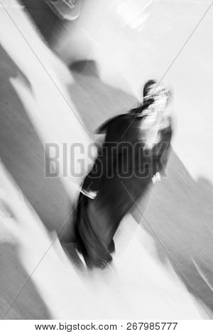 Turkish Woman Is Walking On The Street Where The Sun Sands Soft Shadows To The Ground. Motion Blurr 
