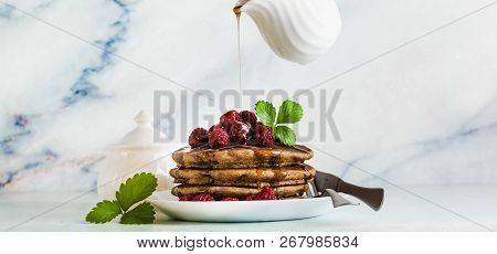 Banner Of Pouring Maple Syrup Over Gluten Free Green Buckwheat Pancakes With Fresh Berries. Deliciou