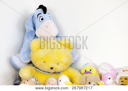 Colorful Peluches All Together Near The White Wall Of A Room