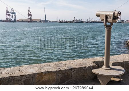 Sightseeing Binoculars Point Across The Harbor In The Direction Of The Ensenada International Termin
