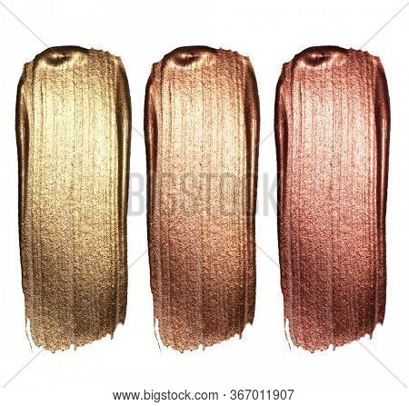 Creative brushstrokes of gold paint isolated on a white background. Gold paint texture.Acrylic gold paint. Smears of cosmetics, blush, highlighter, eye shadow, lipstick.