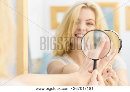 Beautiful Perfectionist Young Woman Checking Her Finger Nails Through Manifying Loupe Glass.