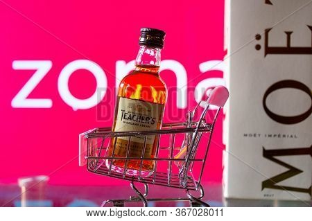 A Bottle Of Whiskey In A Trolley In Front Of A Zomato Board