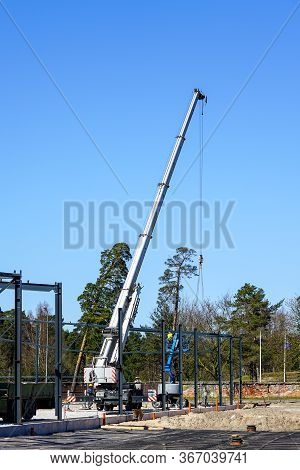 Truck Mounted Crane With A Telescoping Boom At Constructing A Metal Carcas Of A New Building