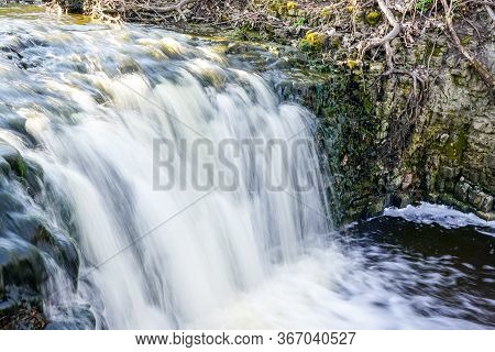 Beautiful View In Spring Of A Waterfall In A Small River