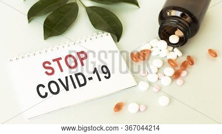 Stop Covid-19 Text With A Stethoscope, Blood Sample Vacuum Tube And A Syringe On A Black Background.