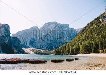 Empty Wooden Boats Moored On The Lago Di Braies On The Background Of Rocky Mountains And Forest. Bra