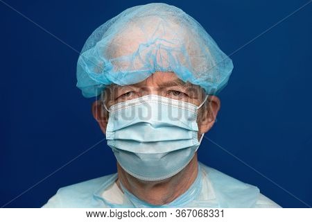 Portrait Of Senior Adult Dressed In Surgical Face Mask With Ear Straps, Covering Nose And Mouth From