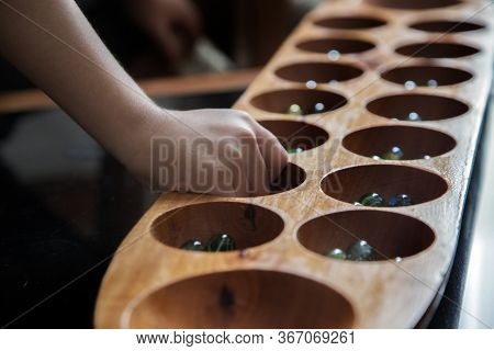 Close Up Hand Hold Glass Ball In Kalaha Game For Practice Math And Strategic Thinking