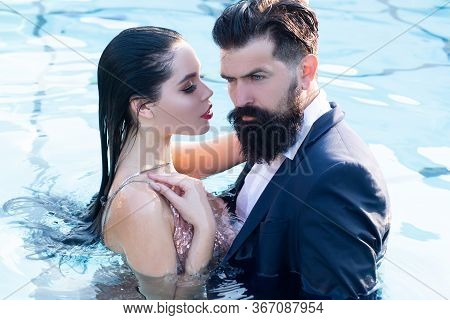 Couple In Dress Having Party In Swimming Pool. Celebrity Couple, Fashionable Pair Of Elegant People.