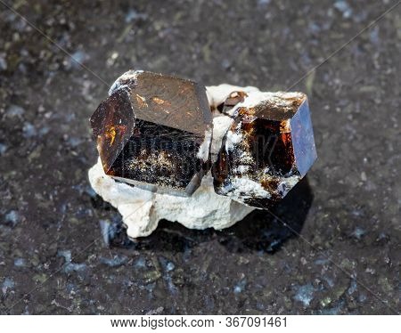 Closeup Of Sample Of Natural Mineral From Geological Collection - Raw Andradite Garnet Rock On Black