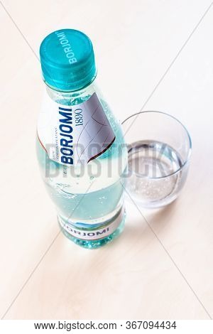 Moscow, Russia - May 10, 2020: Plastic Bottle Of Borjomi And Glass With Sparkling Water On Light Bro
