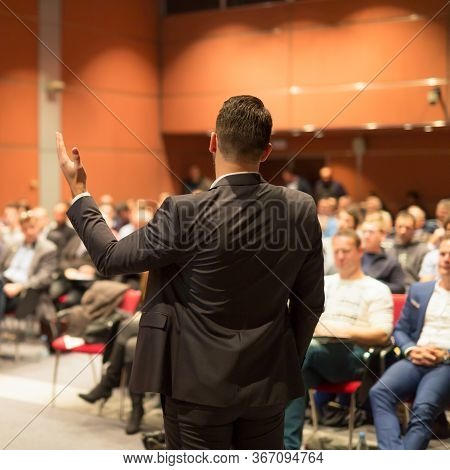 Public Speaker Giving Talk At Business Event.