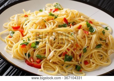 Italian Food Spaghetti Aglio E Olio With Fried Garlic, Parsley And Hot Pepper Close-up In A Plate. H
