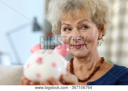 Close-up Of Attractive Elderly Woman Holding Piggy Bank For Money. Colourful Container For Coins And