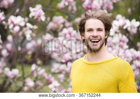 Happy Man Posing In Park With Blossoming Trees