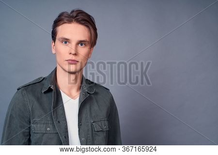 Portrait Of A Young Caucasian Guy, Blond With Blue Eyes, In Modern Casual Clothes, In A White T-shir
