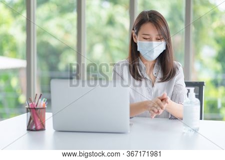 Business Woman Wearing Mask And Using Personal Sanitizer To Cleaning Her Hand In Office To Keep Hygi
