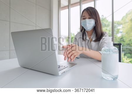 Business Woman Wearing Mask And Using Personal Sanitizer To Cleaning Her Hand In Office To Keep Hygi