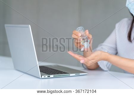 Business Woman Wearing Mask And Using Personal Sanitizer To Cleaning Her Hand In Office To Keep Hygi