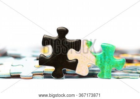 Two Bright Puzzle Pieces Connected In Front Of Separated Pieces. White Background.