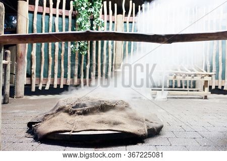 Smoke And Dust Fly As Food Is Being Prepared For A Traditional Maori Feast Or Hangi, By Steaming Thr