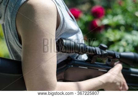 The Girl Is Holding A Large Sniper Rifle. Young Girl With A Gun In Her Hands. Air Rifle With A Teles