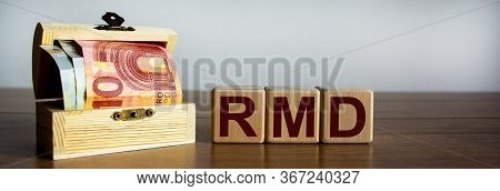 Concept Word 'rmd' On Cubes On A Beautiful Wooden Table, Small Chest With Euro Bills. Beautiful Back