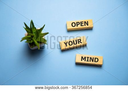 Wood Letters Open Your Mind On Blue Background.