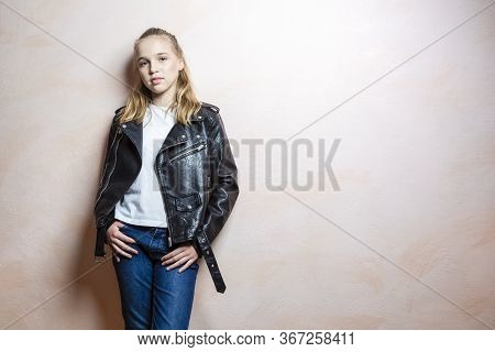 Portrait Of Calm Teenager Girl Posing In Black Leaher Jacket Indoors.